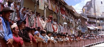 Movie still from “Around the World in 80 Days” (1956), directed by John Farrow – A group of people sitting on top of a wooden fence; Extreme Wide shot, High angle