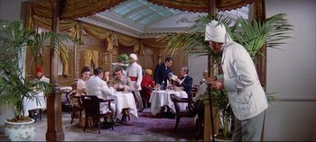 Movie still from “Around the World in 80 Days” (1956), directed by John Farrow – A group of people sitting at tables in a restaurant; Wide shot, High angle