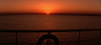 Movie still from “Around the World in 80 Days” (1956), directed by John Farrow – The sun is setting over the ocean as seen from a pier; Extreme Wide shot, High angle