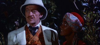 Movie still from “Around the World in 80 Days” (1956), directed by John Farrow – A man and a woman standing next to each other in front of trees; Close Up shot, Over the shoulder angle