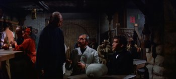 Movie still from “Around the World in 80 Days” (1956), directed by John Farrow – A group of men standing next to each other in a room; Medium shot, Over the shoulder angle