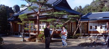 Movie still from “Around the World in 80 Days” (1956), directed by John Farrow – Two people standing in front of a building; Extreme Wide shot, Low angle