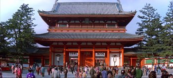 Movie still from “Around the World in 80 Days” (1956), directed by John Farrow – A group of people standing outside of an asian building; Extreme Wide shot, High angle