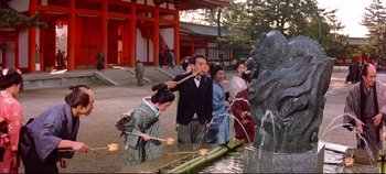 Movie still from “Around the World in 80 Days” (1956), directed by John Farrow – A group of people standing next to each other near a fountain; Wide shot, Low angle