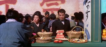 Movie still from “Around the World in 80 Days” (1956), directed by John Farrow – A man and a woman sitting in front of a table of food; Medium shot, Low angle