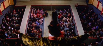 Movie still from “Around the World in 80 Days” (1956), directed by John Farrow – A crowd of people sitting in a room; Extreme Wide shot, Overhead angle