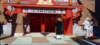 Movie still from “Around the World in 80 Days” (1956), directed by John Farrow – A person standing in front of a circus building; Wide shot, Low angle