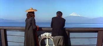 Movie still from “Around the World in 80 Days” (1956), directed by John Farrow – Two people standing on a deck looking at a mountain; Medium shot, High angle
