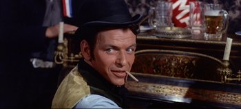 Movie still from “Around the World in 80 Days” (1956), directed by John Farrow – A person wearing a hat and holding a cigarette; Close Up shot, Over the shoulder angle