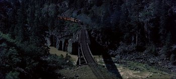 Movie still from “Around the World in 80 Days” (1956), directed by John Farrow – A train traveling over a bridge in the middle of the night; Extreme Wide shot, High angle