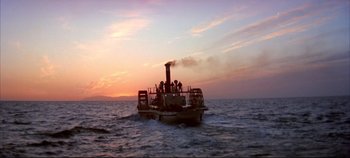 Movie still from “Around the World in 80 Days” (1956), directed by John Farrow – A boat with people on it in the ocean at sunset; Extreme Wide shot, Low angle
