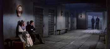 Movie still from “Around the World in 80 Days” (1956), directed by John Farrow – A man sitting on a bench next to a wall; Wide shot, High angle