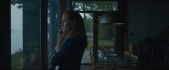 Movie still from “Arrival” (2016), directed by Denis Villeneuve – A woman sitting at a table talking on a phone; Medium shot, Low angle