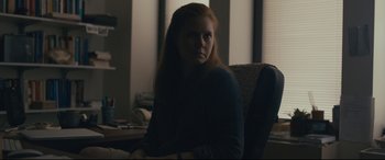 Movie still from “Arrival” (2016), directed by Denis Villeneuve – A woman sitting in a chair in a room; Medium shot, Over the shoulder angle