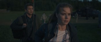 Movie still from “Arrival” (2016), directed by Denis Villeneuve – A woman is walking in a field with a man behind her; Medium shot, Over the shoulder angle