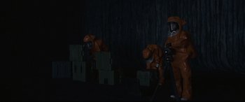 Movie still from “Arrival” (2016), directed by Denis Villeneuve – A group of people in orange suits and masks; Wide shot, High angle