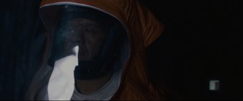 Movie still from “Arrival” (2016), directed by Denis Villeneuve – A man wearing a helmet and a raincoat; Close Up shot, Low angle