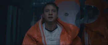 Movie still from “Arrival” (2016), directed by Denis Villeneuve – A man with an orange rain jacket and an umbrella; Close Up shot, Low angle
