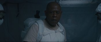 Movie still from “Arrival” (2016), directed by Denis Villeneuve – A man in a white shirt and a backpack; Close Up shot, Low angle