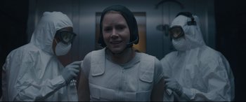 Movie still from “Arrival” (2016), directed by Denis Villeneuve – A woman wearing a helmet is standing next to two other people; Medium shot, Over the shoulder angle