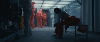 Movie still from “Arrival” (2016), directed by Denis Villeneuve – A woman is kneeling down in an industrial setting; Wide shot, Low angle