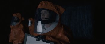 Movie still from “Arrival” (2016), directed by Denis Villeneuve – A person in a space suit is reflected in a mirror; Medium shot, Low angle