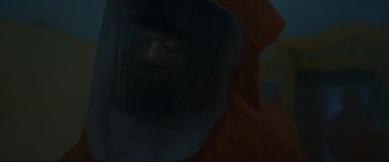 Movie still from “Arrival” (2016), directed by Denis Villeneuve – A man wearing a protective suit and a face shield; Close Up shot, Over the shoulder angle