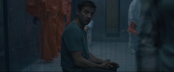 Movie still from “Arrival” (2016), directed by Denis Villeneuve – A man sitting on a chair in a room; Medium shot, Over the shoulder angle