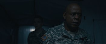 Movie still from “Arrival” (2016), directed by Denis Villeneuve – Two men in fatigues are standing next to each other; Close Up shot, Over the shoulder angle