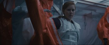 Movie still from “Arrival” (2016), directed by Denis Villeneuve – A woman in a space suit is standing in front of a building; Medium shot, Low angle
