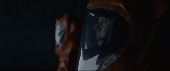 Movie still from “Arrival” (2016), directed by Denis Villeneuve – A man wearing a protective suit is looking into the distance; Close Up shot, Low angle