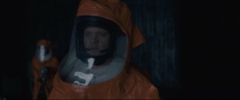 Movie still from “Arrival” (2016), directed by Denis Villeneuve – A man in a hazmat suit is holding a pipe; Close Up shot, High angle