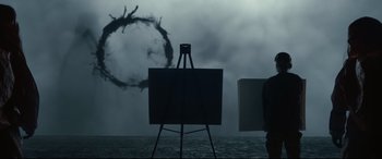 Movie still from “Arrival” (2016), directed by Denis Villeneuve – An easel in front of an image of an octopus; Medium shot, Over the shoulder angle