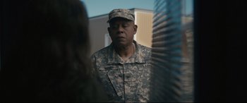 Movie still from “Arrival” (2016), directed by Denis Villeneuve – A man in fatigues is standing in front of a woman; Medium shot, Over the shoulder angle
