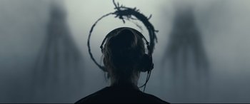Movie still from “Arrival” (2016), directed by Denis Villeneuve – A person wearing headphones and looking at a tree branch; Extreme Close Up shot, Overhead angle