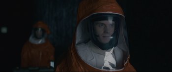 Movie still from “Arrival” (2016), directed by Denis Villeneuve – A man in a spacesuit is looking into a mirror; Close Up shot, Over the shoulder angle