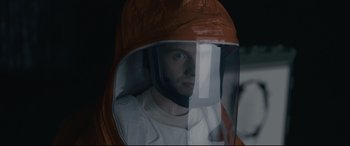 Movie still from “Arrival” (2016), directed by Denis Villeneuve – A man wearing a protective suit and a helmet; Close Up shot, Low angle