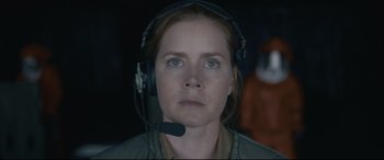 Movie still from “Arrival” (2016), directed by Denis Villeneuve – A woman wearing a headset and looking into the distance; Close Up shot, Over the shoulder angle