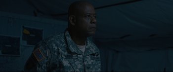 Movie still from “Arrival” (2016), directed by Denis Villeneuve – A man in fatigues is standing in the dark; Medium shot, Low angle