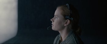 Movie still from “Arrival” (2016), directed by Denis Villeneuve – A woman wearing a headset looking to her left; Close Up shot, Over the shoulder angle