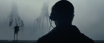 Movie still from “Arrival” (2016), directed by Denis Villeneuve – A man with a headset on in front of an image of an octopus; Close Up shot, Over the shoulder angle