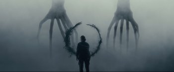 Movie still from “Arrival” (2016), directed by Denis Villeneuve – A man standing in front of a foggy wall with two giant hands; Extreme Wide shot, Over the shoulder angle