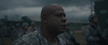 Movie still from “Arrival” (2016), directed by Denis Villeneuve – A man in military fatigues is looking into the distance; Close Up shot, Low angle