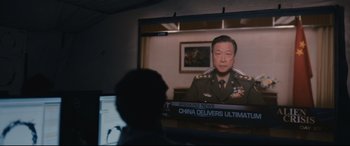 Movie still from “Arrival” (2016), directed by Denis Villeneuve – A man is watching a news story on a television screen; Medium shot, Over the shoulder angle