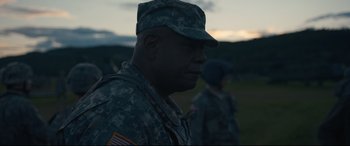 Movie still from “Arrival” (2016), directed by Denis Villeneuve – A man in fatigues is standing in a field; Medium shot, Over the shoulder angle
