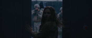 Movie still from “Arrival” (2016), directed by Denis Villeneuve – A woman standing in front of a group of soldiers; Medium shot, Over the shoulder angle