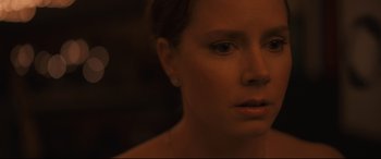 Movie still from “Arrival” (2016), directed by Denis Villeneuve – A woman's face in the dark; Close Up shot, Over the shoulder angle