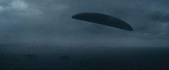 Movie still from “Arrival” (2016), directed by Denis Villeneuve – An image of an airplane flying in the sky over the ocean; Extreme Wide shot, High angle
