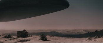 Movie still from “Arrival” (2016), directed by Denis Villeneuve – A military vehicle is parked in the desert near an airplane; Extreme Wide shot, High angle
