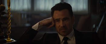 Movie still from “Artemis Fowl” (2020), directed by Kenneth Branagh – A person wearing a suit and tie; Close Up shot, Over the shoulder angle